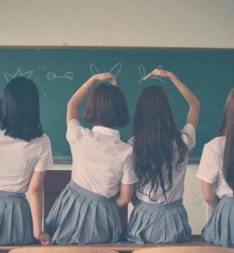 Adolescentes en uniforme escolar participando en clase sobre salud sexual en el aula